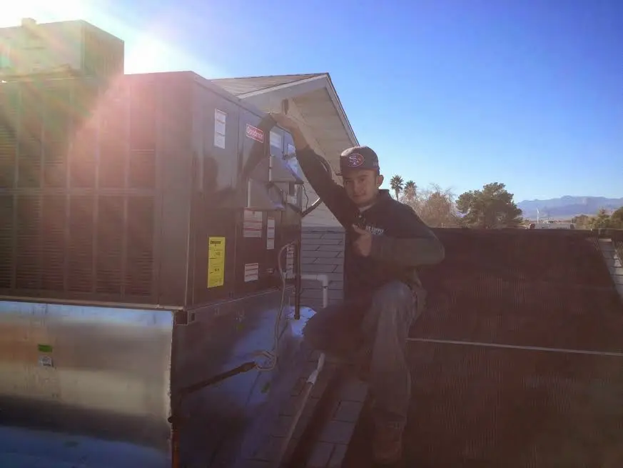 HVAC technician performing Air Duct Cleaning on a rooftop unit in Marion